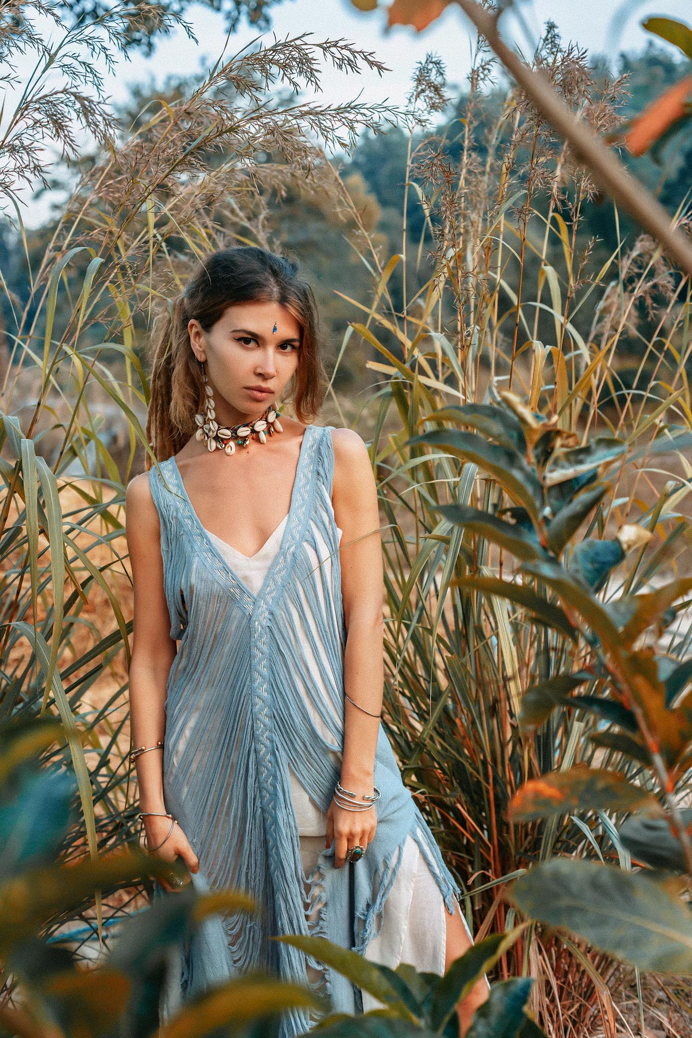 This sleeveless and lightweight dress features an open "V" side cut and beautiful hand-looped tassel edging.