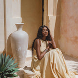 Flowy Gold Goddess Dress adorned with small jingle bells; inspired by Indian beliefs. Hand-embroidered by local artisans and colored with organic ombré dyes.