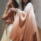 Two women in bohemian-style clothing and wide-brimmed hats. The woman on the left wears a flowing, sleeveless dress. On the right, a woman draped in AYA Sacred Wear's Powder Pink Boho Poncho rests her arm on her companion's shoulder.