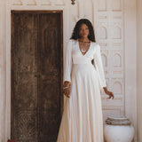Stunning off-white silk bridal dress with a bohemian goddess vibe, featuring an open back and flowing bell sleeves.