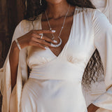 Dreamy cream-colored peace silk dress perfect for the ethereal bride, exuding bohemian charm with its captivating open back and elegant bell sleeves.