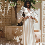 Capture attention in this fairy tale-inspired off-white silk dress, accentuated by bell sleeves and an open back design, perfect for a boho-chic bride.